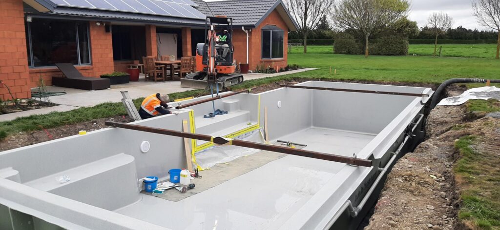 A fibreglass in-ground pool being installed