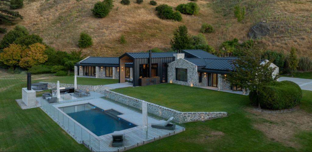 Modern Bermuda pool with sleek design, outdoor lounge area, and lush green landscaping for luxury backyard comfort. Perfect for entertaining and relaxation.