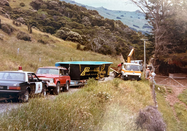 Bermuda Pools construction site with trucks and equipment in a scenic hillside landscape.