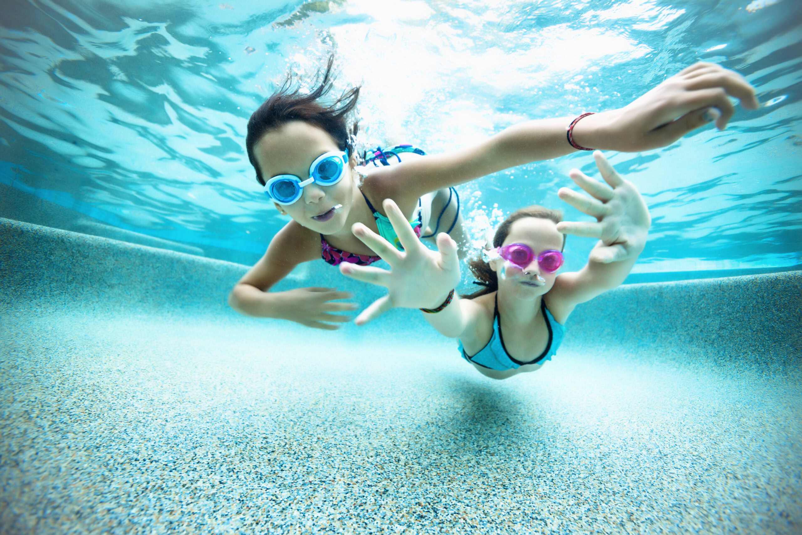 Underwater photo of two girls swimming in one of our fibreglass pool models
